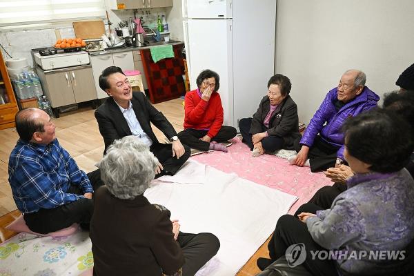 President Yoon Suk Yeol (2nd from L, rear) meets with a group of elderly people during a visit to an unregistered community center for senior citizens in Seoul's Gangbuk Ward on Feb. 7, 2024, to wish them a happy Lunar New Year and look at ways to improve welfare services for the elderly, in this photo released by the presidential office. (PHOTO NOT FOR SALE) (Yonhap)