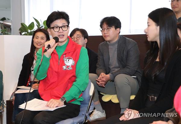 Han Dong-hoon (front, L), leader of the ruling People Power Party, introduces the party's campaign pledges on climate change at a book cafe in southern Seoul on Feb. 27, 2024. (Pool photo) (Yonhap)