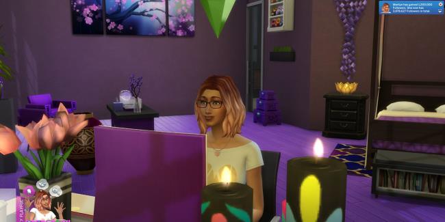 Sims 4 Sim sitting at their desk on their laptop