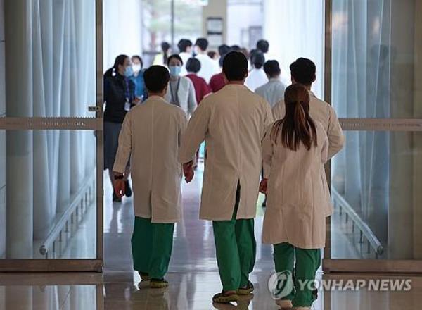 Medical staffers walk into an overpass to move to another building at a general hospital in Seoul on Feb. 29, 2024. (Yonhap) 