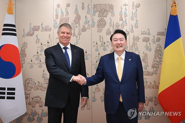 President Yoon Suk Yeol (R) shakes hands with Romanian President Klaus Iohannis during their summit meeting at the presidential office in Seoul on April 23, 2024, in this photo provided by Yoon's office. (PHOTO NOT FOR SALE) (Yonhap)